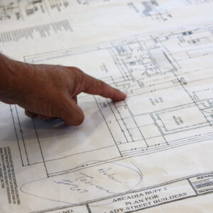 A person’s hand points to a specific area on the Arcadia Buff 2 architectural floor plan for new home construction in Columbia.